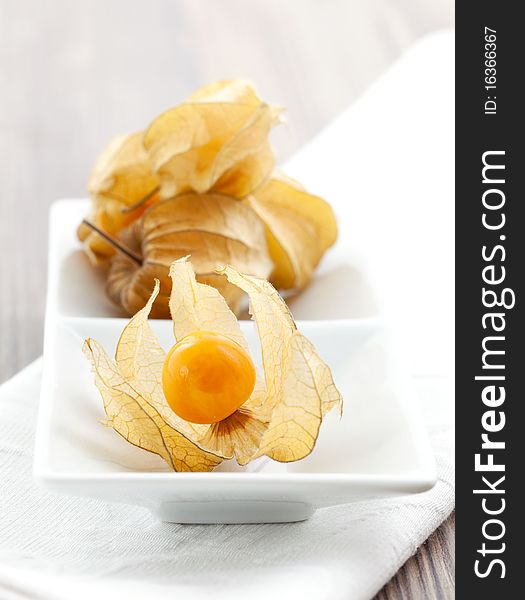 Open physalis on plate with physalis in background