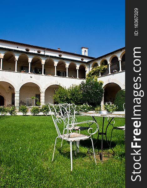 Traditional italian white villa set against a clear deep blue sky. Alfresco dining table in the foreground. Traditional italian white villa set against a clear deep blue sky. Alfresco dining table in the foreground.