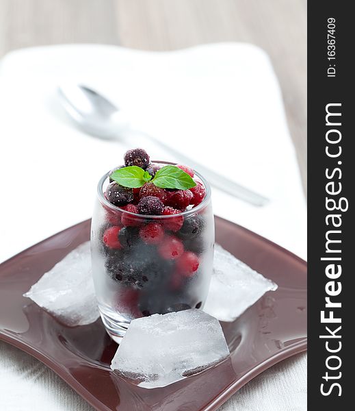 Frozen berries in a glass with spoon