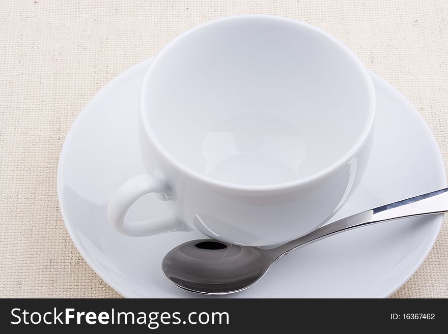 Empty ceramic cup with a saucer on a white background.