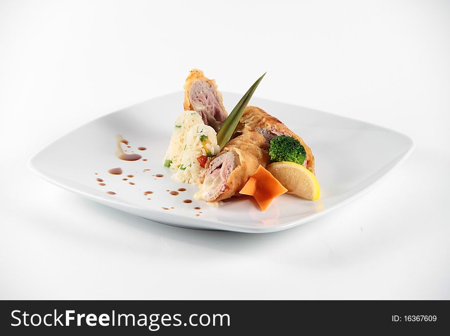 Meat rolls served and decorated with vegeables on a white plate. Meat rolls served and decorated with vegeables on a white plate