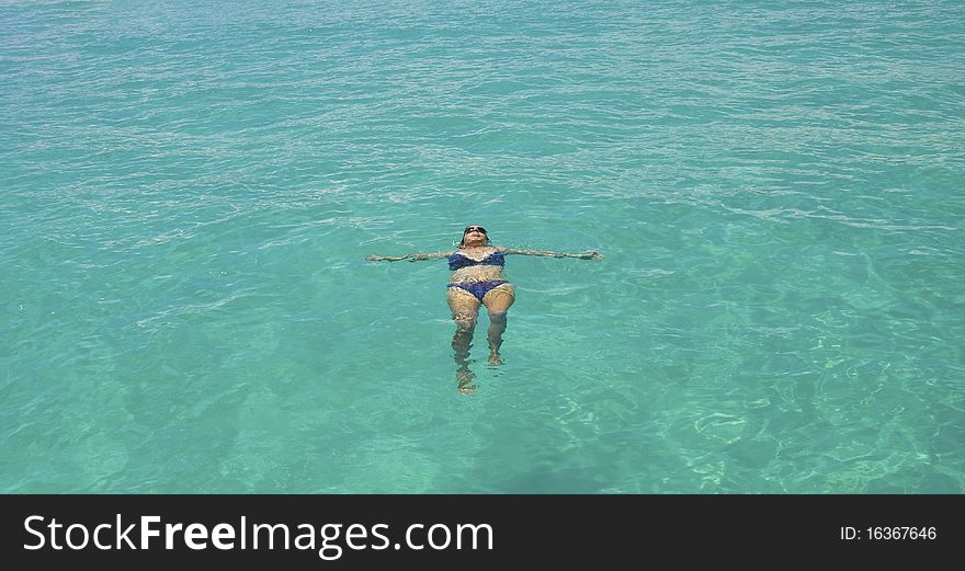 Girl Swimming In The Clear Blue Sea