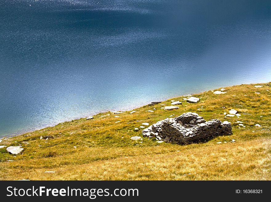 Mountain lake with ruins of a house