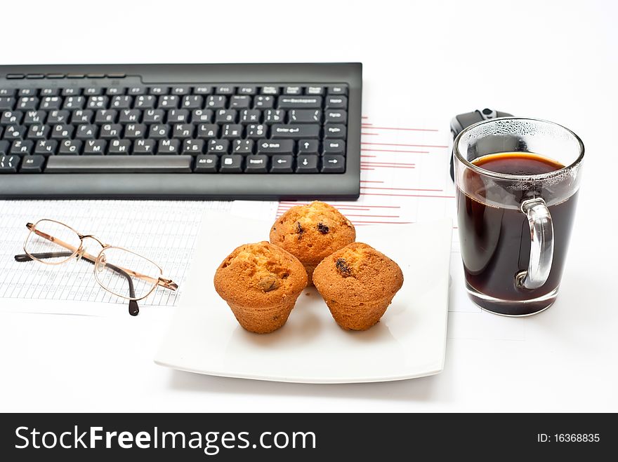 Business still-life with diagrams, glasses, coffee, cakes on plate and keyboard. Business still-life with diagrams, glasses, coffee, cakes on plate and keyboard