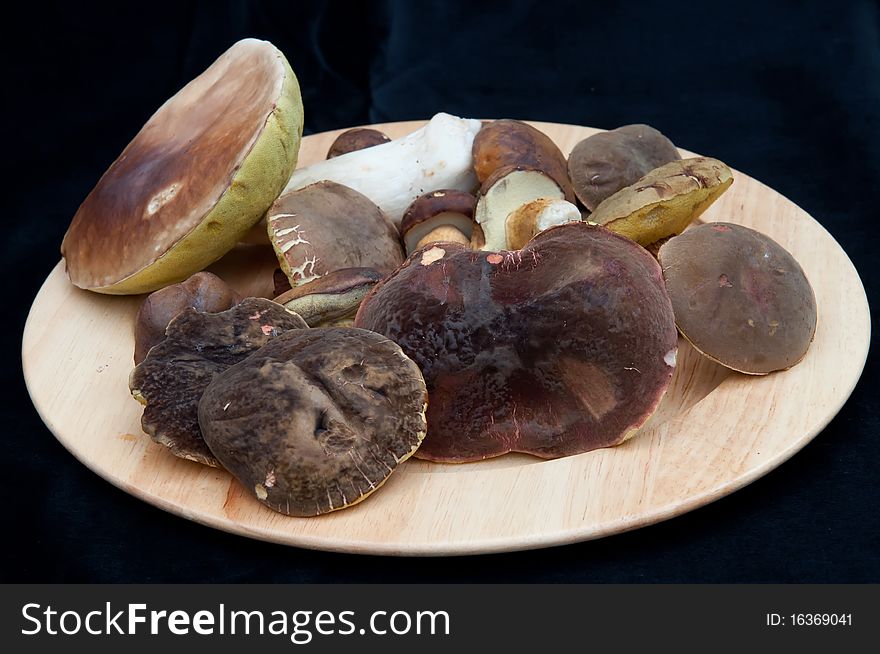 Mushrooms on the plate and black background. Mushrooms on the plate and black background.