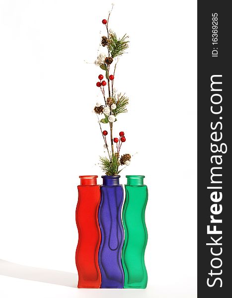 Christmas decoration in colored glass vase on white background