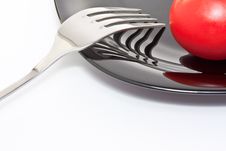 Red Tomato On A Black Plate With Fork Stock Photos