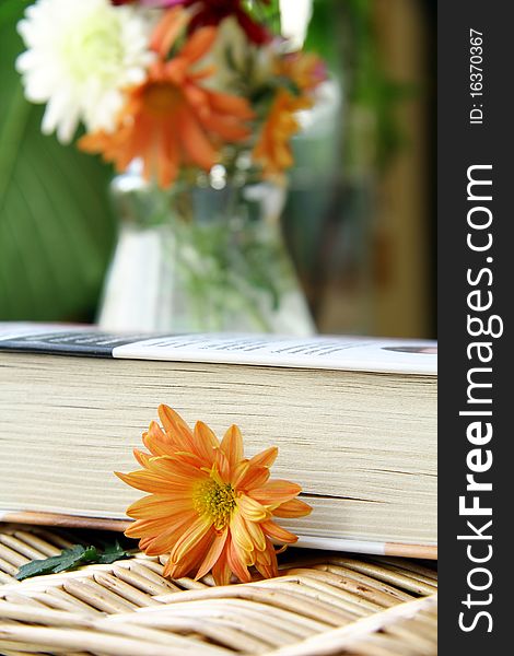 Closed book on a table with flowers