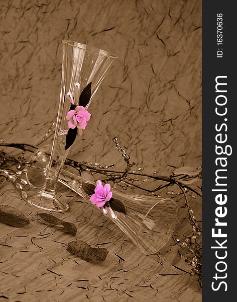 Champagne glasses on sepia with pink roses on the glass. Champagne glasses on sepia with pink roses on the glass
