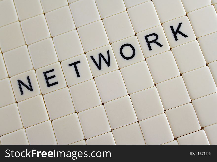 The word 'network' spelled out in tiles in the middle of blank tiles.