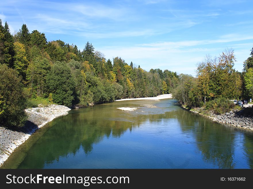 River in autumn with colorful trees and blue sky