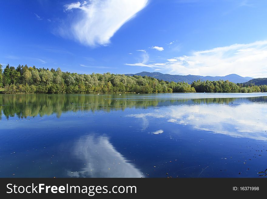 Blue lake with colorful wood and blue sky in autumn. Blue lake with colorful wood and blue sky in autumn