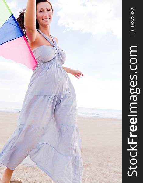 Smiling happy healthy woman walking on beach with kite in winter autumn spring time. Smiling happy healthy woman walking on beach with kite in winter autumn spring time