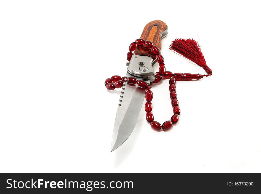 The hunting knife and Muslim beads are isolated on a white background