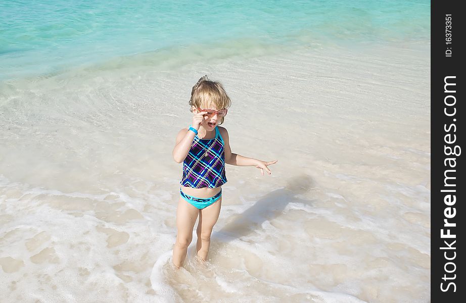 Little girl playing in sea on the Aruba's beach in summer day. Little girl playing in sea on the Aruba's beach in summer day.