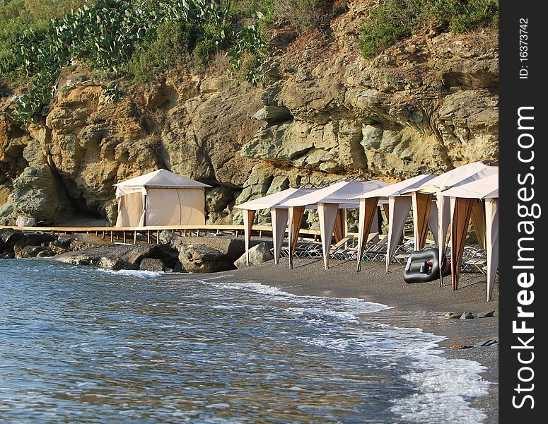 Beach chairs and tents in private beach on the island of Crete. Beach chairs and tents in private beach on the island of Crete