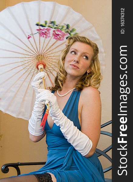 Blond woman dressed up as a 1940s pinup holding an umbrella. Blond woman dressed up as a 1940s pinup holding an umbrella