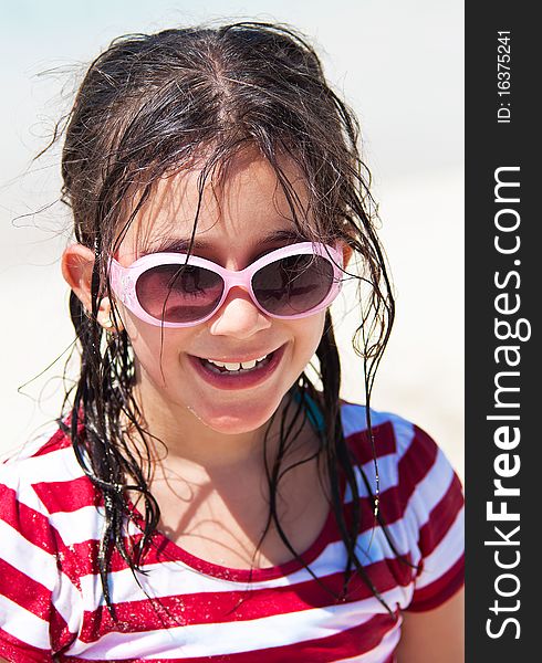 Beautiful girl with sunglasses and messy hair smiling at the camera. Beautiful girl with sunglasses and messy hair smiling at the camera