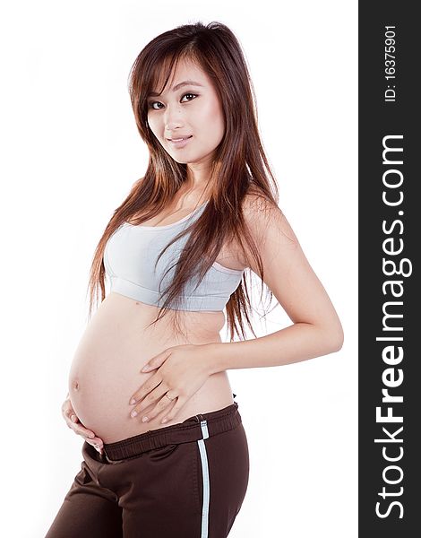 A pregnant woman is wearing an outfit used to work out in.  She is holding her belly. A pregnant woman is wearing an outfit used to work out in.  She is holding her belly.