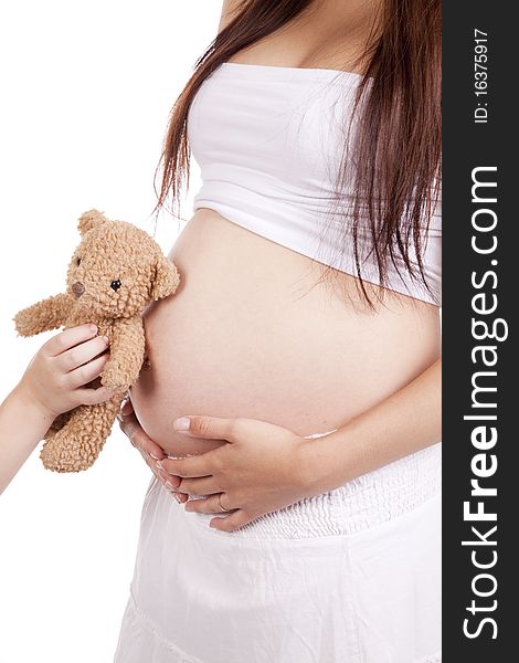 A pregnant moms body with a child holding a bear by her belly. A pregnant moms body with a child holding a bear by her belly
