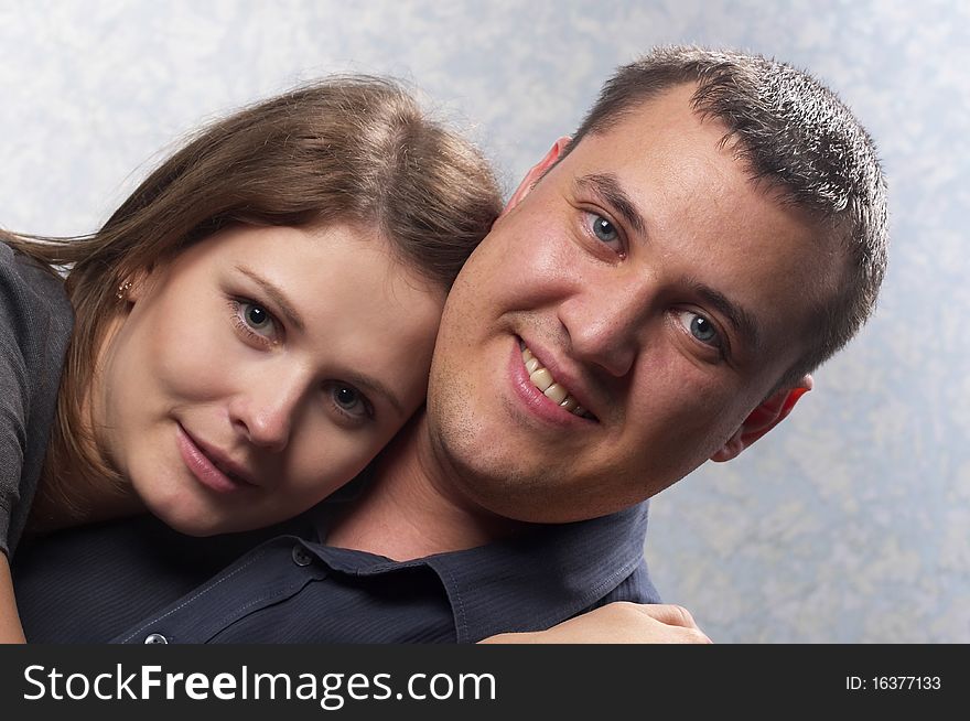 Young smiling couple over light defocused background. Young smiling couple over light defocused background