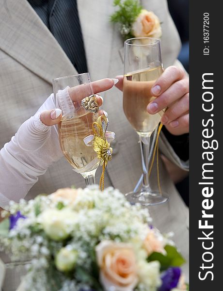 Bride and groom are holding champagne glasses