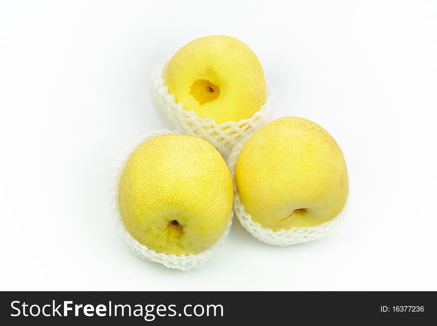 Nashi Pears in shipping net on a white surface.