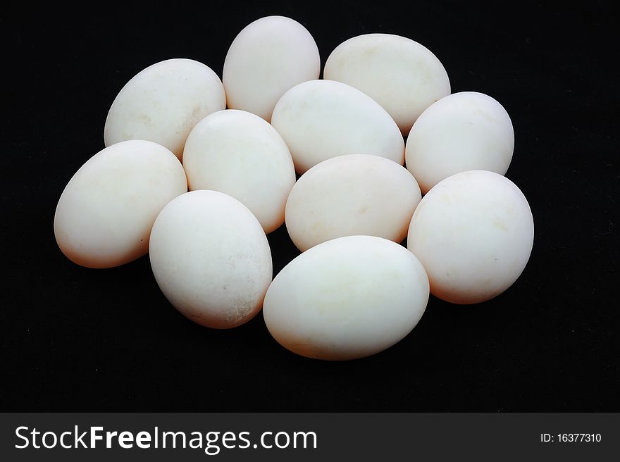 White eggs on black background.