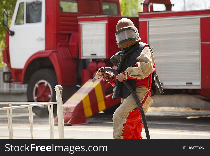 Worker in a protective suit spraying sand