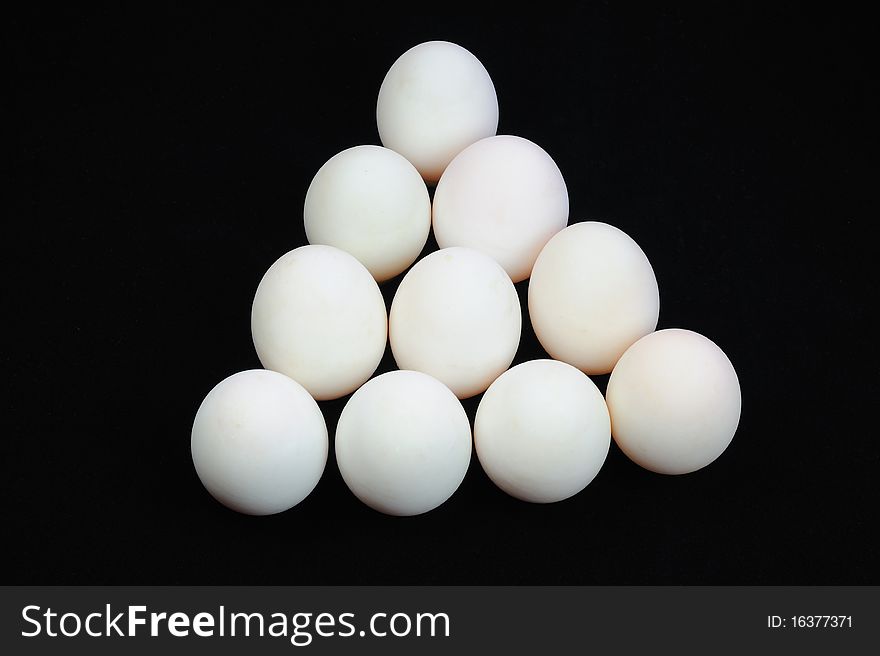 White eggs on black background.