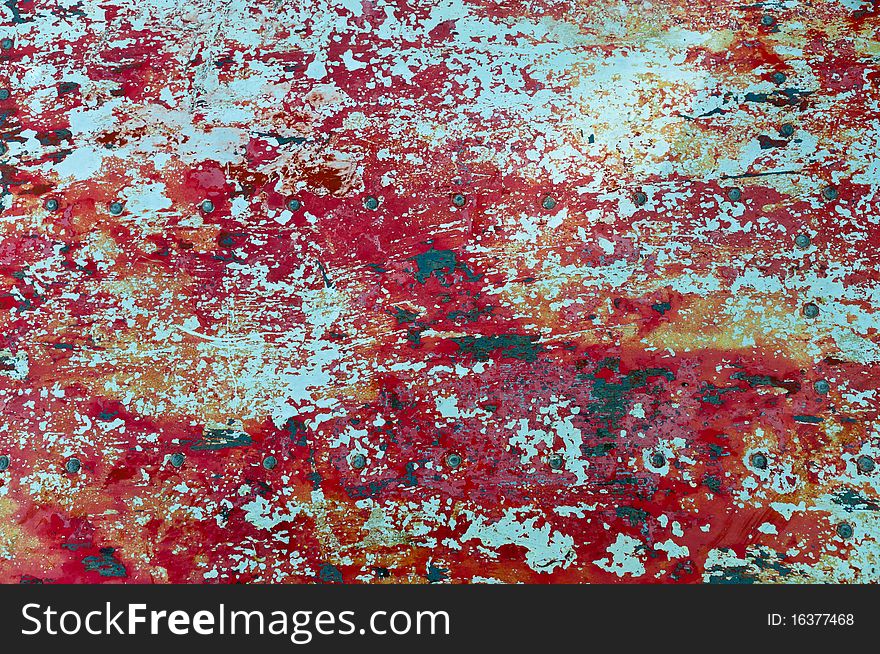 The texture of flaked red paint on metal surface. The texture of flaked red paint on metal surface