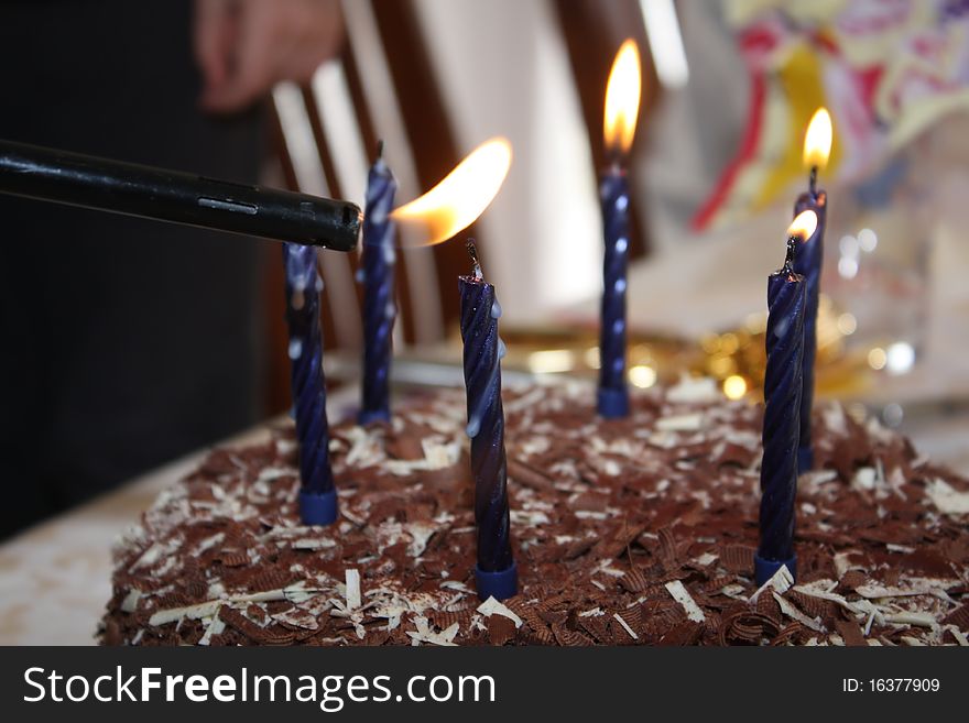 Lighting birthday candles on a chocolate cake