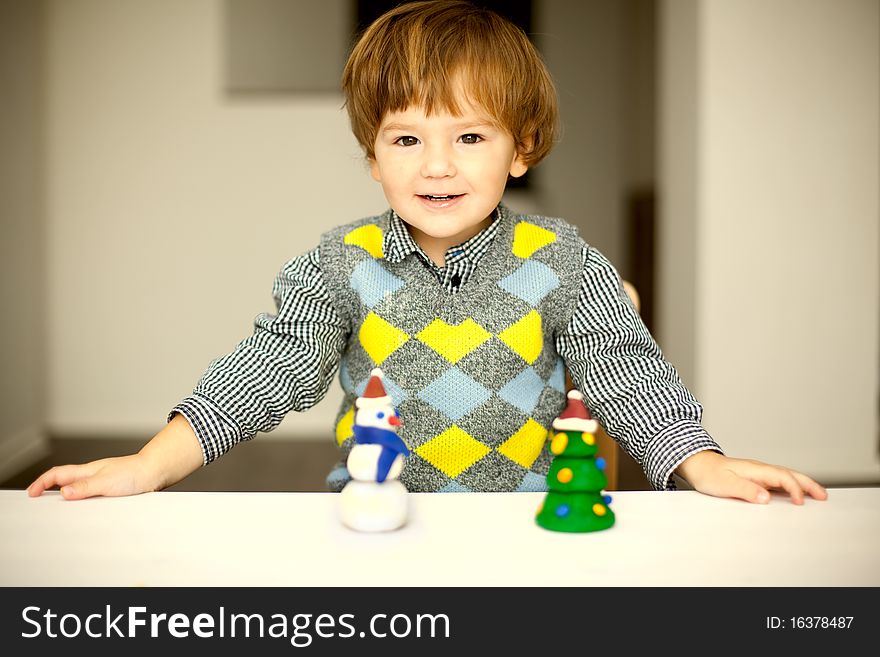 A child making a snowman and christmas tree of plasticine. A child making a snowman and christmas tree of plasticine