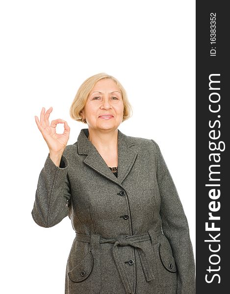 Portrait of a smiling senior business woman showing okay symbol isolated on white background