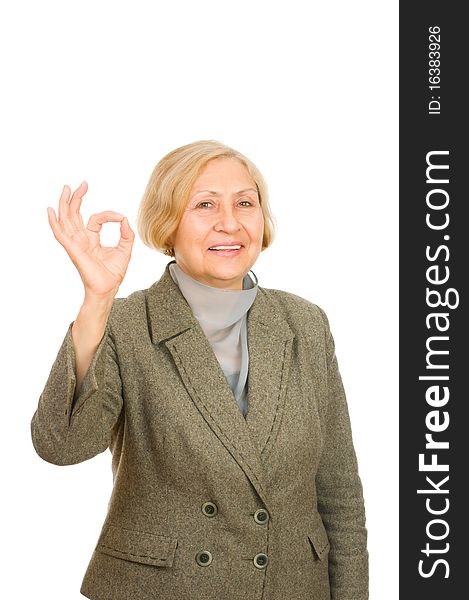 Portrait of a smiling senior business woman showing okay symbol isolated on white background