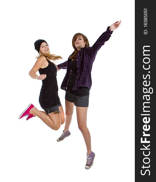 Two young teenage girls with trendy stylish clothes jumpingover white background. Two young teenage girls with trendy stylish clothes jumpingover white background.