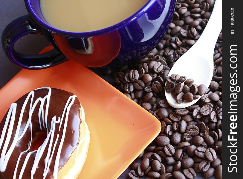 Cup of coffee with donut and coffee beans and wooden spoon. Cup of coffee with donut and coffee beans and wooden spoon