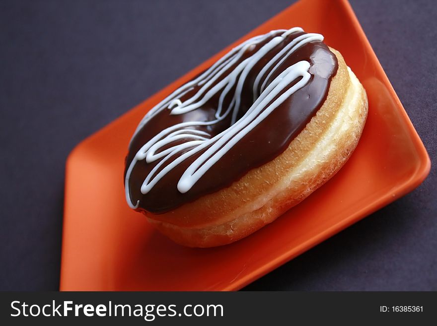 Donut on orange square plate. Donut on orange square plate