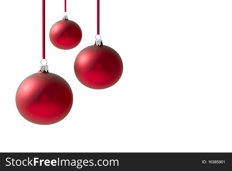 Christmas balls hanging on reds ribbons over a white background background