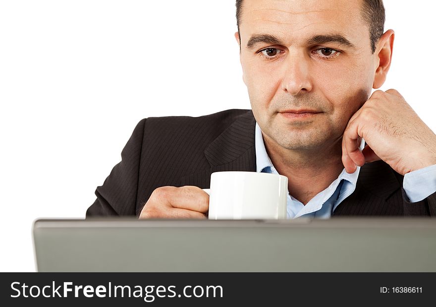 Portrait of businessman behind laptop drinking coffee, isolated. Portrait of businessman behind laptop drinking coffee, isolated