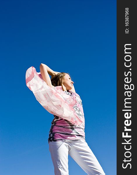 Happy young lady playing with her scarf near the sea, in the wind. Happy young lady playing with her scarf near the sea, in the wind