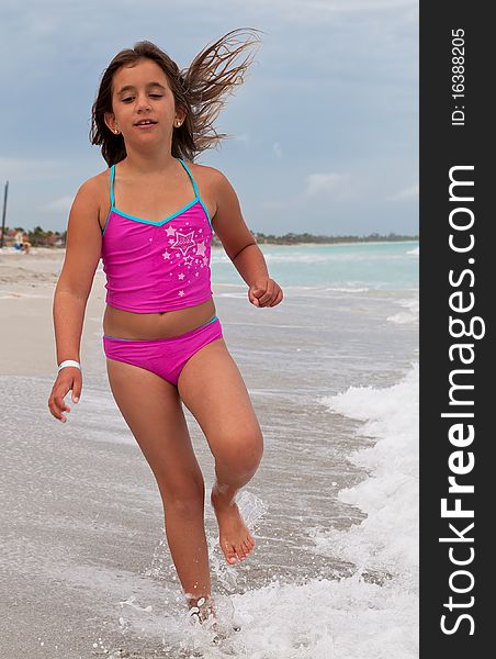 Girl On A Pink Swimsuit Running On A Beach