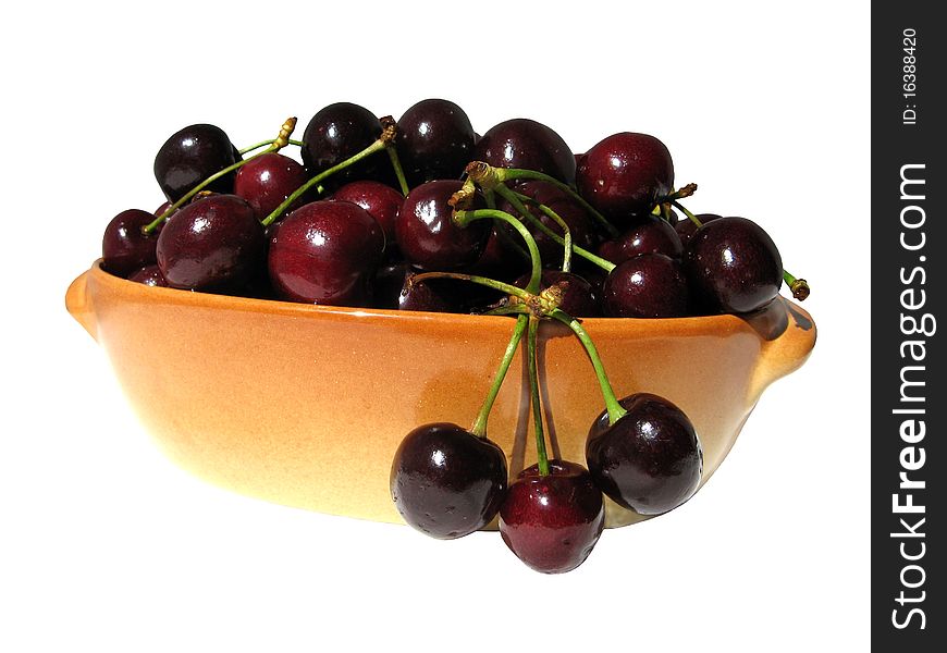 Ripe sweet cherries in the oval buff ceramic dish isolated on white