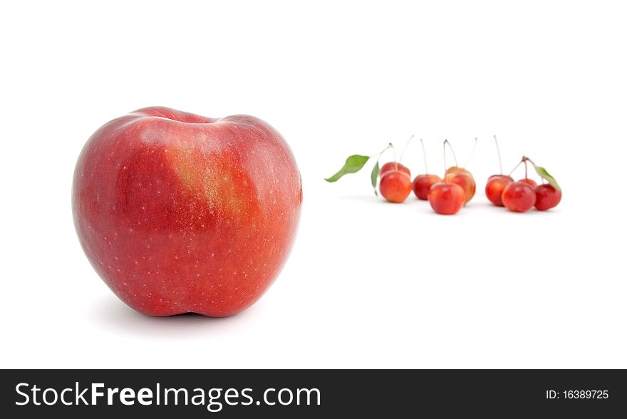 Big red apple with small Chinese cherry apples in the background, isolated on white. Big red apple with small Chinese cherry apples in the background, isolated on white.