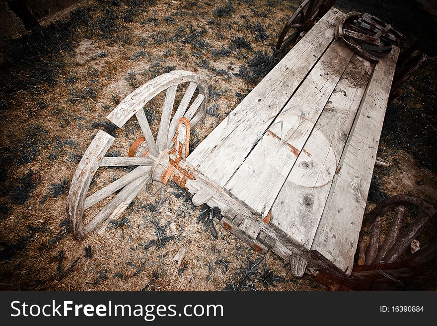 Old broken wooden wagon and wheel. Old broken wooden wagon and wheel.