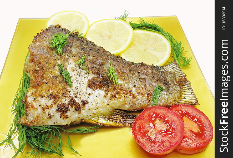 Grilled river fish with vegetables on yellow plate. Grilled river fish with vegetables on yellow plate