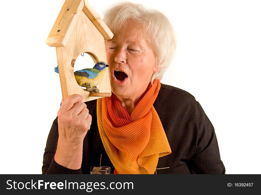 Senior woman is speaking with a bird. Senior woman is speaking with a bird