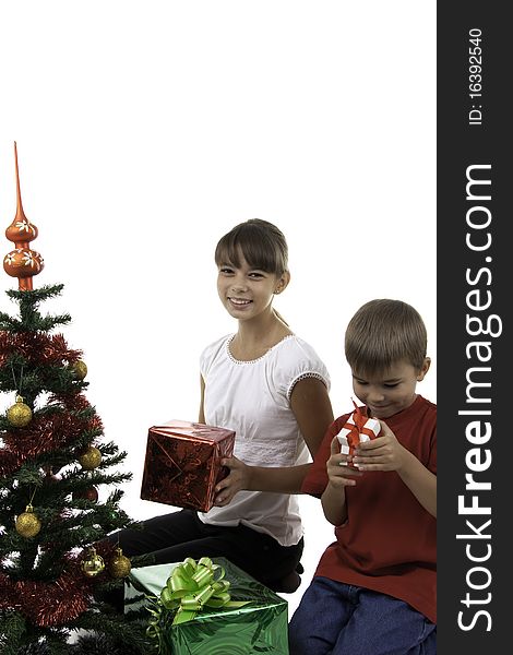 Two children with gifts near to a New Year tree. Two children with gifts near to a New Year tree