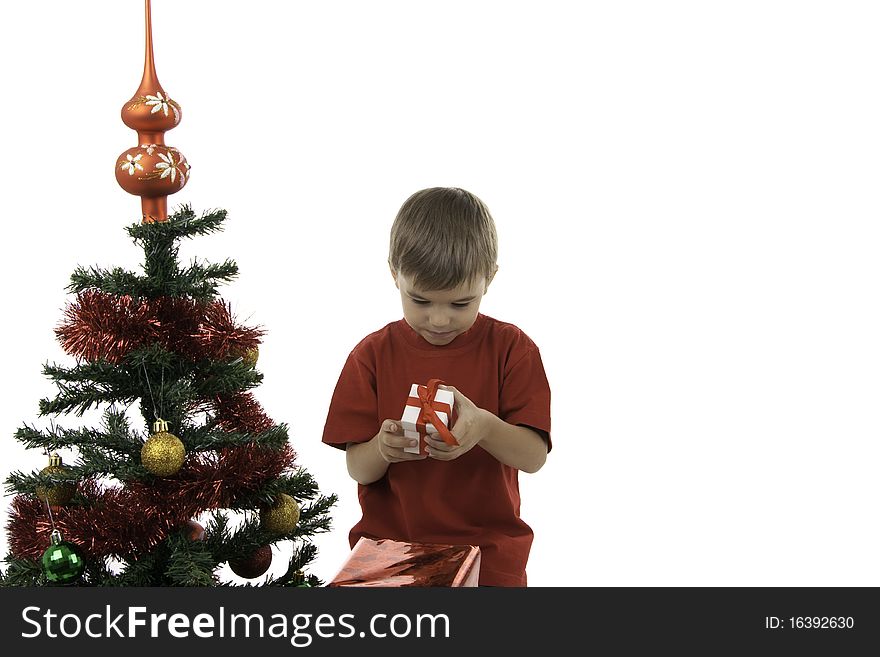 The boy with gifts near to a New Year tree. The boy with gifts near to a New Year tree