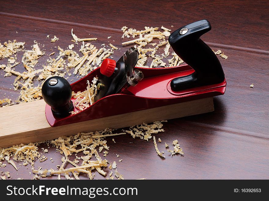 Red plane on brick and shavings.